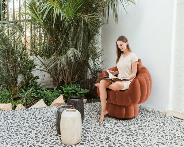 Side view highlighting the ergonomic barrel backrest and wide upholstered seat of the pumpkin reading chair.
